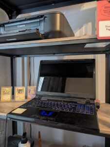 A dusty bulky old laptop on a shelf
